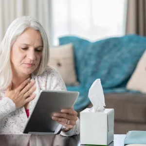 A senior woman talking to her doctor, virtually.
