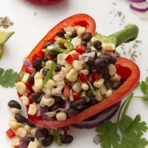 Half of red bell pepper stuffed with bean/corn salsa with lime garnish