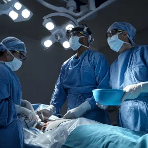 Surgeons performing a surgery in an operating room.