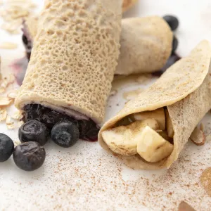 Two crepes filled with blueberries, one crepe filled with potatoes