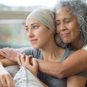Woman in 50s embracing her mid 30s daughter