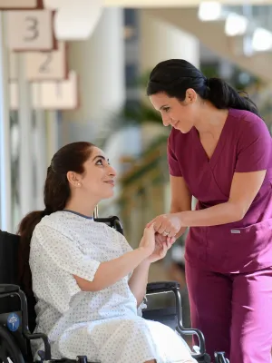 Female nurse giving a hopeful smile to female patient.