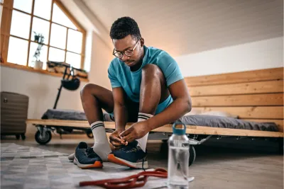 A young man tying his shoes