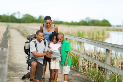 A family walking on a boardwalk together.