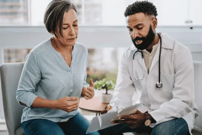 A middle-aged woman speaks to her doctor.