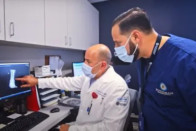 Dr. Michael Hawks (seated), orthopedic trauma surgeon and medical director for AdventHealth and Rothman Orthopaedics in Central Florida, confers with a fellow physician.