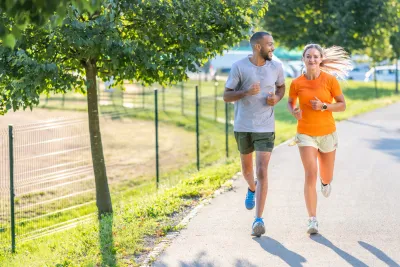 A man and woman running outdoors on a sunny day