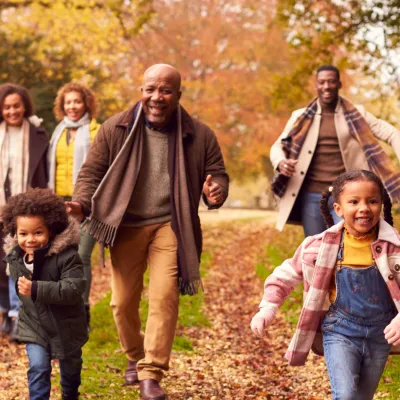 A family walking together outdoors in the fall.