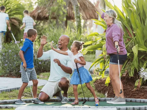 family playing mini golf during spring break