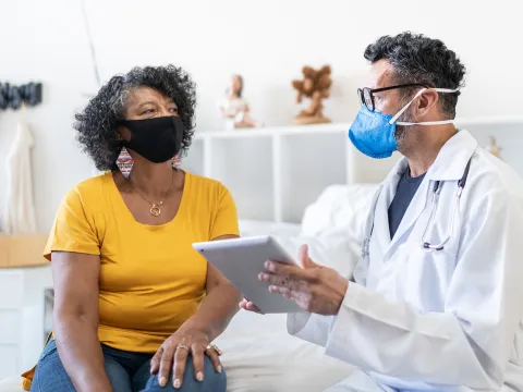 A Doctor Goes Over Details of a Case with the Patient while in an Exam Room.