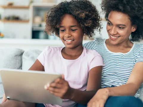 A Mother and Daughter Enjoy Surfing the Internet Together While Sitting in Their Home.