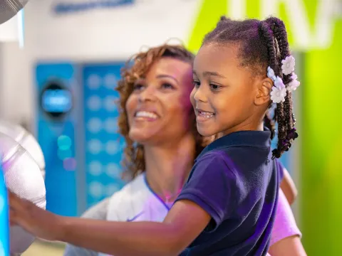 A Woman Hold Her Daughter in the Gift Shop of The Amway Center