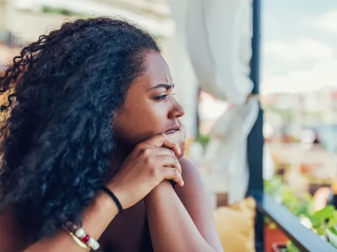 A Woman Stares into the Distance with a Worried Look on Her Face.
