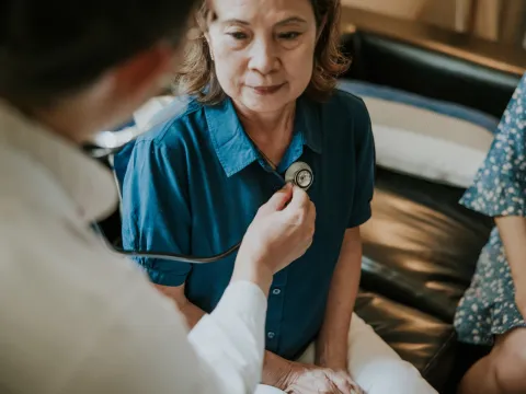 A Doctor Listens to a Patient's Heart with a Stethoscope