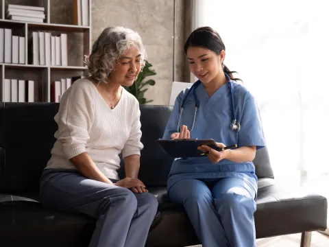 A Doctor and Her Patient Sit in an Office an Talk about Her Charts.