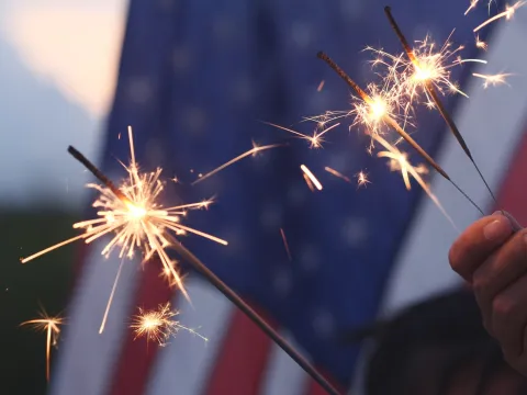 3 Sparklers Burn in Front of The American Flag