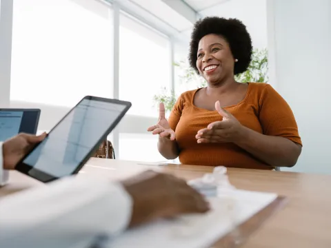 A Smiling Patient Speaks to Her Doctor About her Treatment