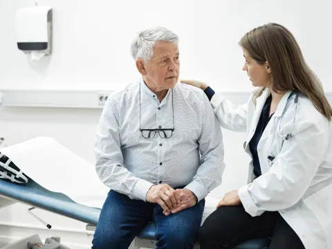 Older man talking with his doctor in an exam room