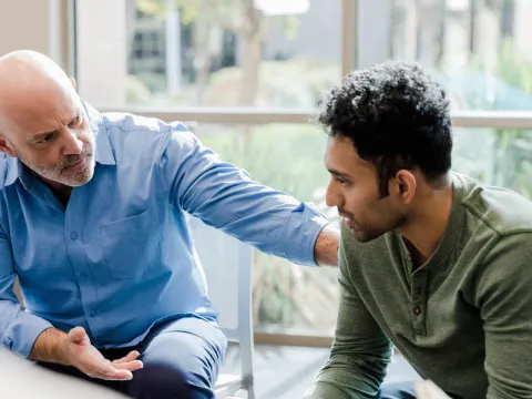 A Therapist Speaks to His Patient and Put's his Hand on His Shoulder