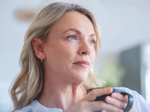 A Woman Sits and Drinks Coffee