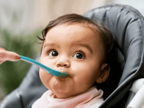 A Close Up of a Baby Being Spoon Fed