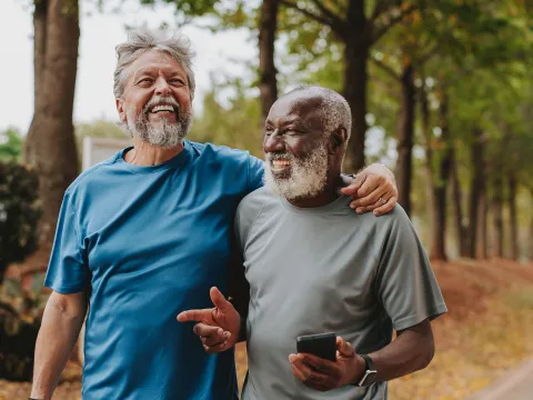 Two older men walking outdoors together.