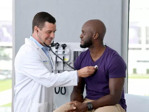 A Provider Checks a Patient's Heart in an Exam Room