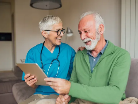 A Nurse Smiles as She Goes Over a Patient's Chart with Him