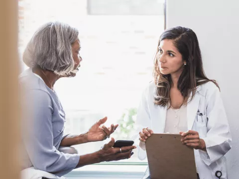 A Doctor and Patient Speak in an Exam Room