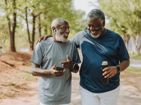 Two Men Walk and Laugh Through a Park