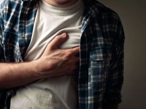 Man clutching his chest.