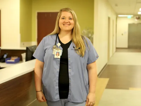 A white woman standing in a hall at the hospital