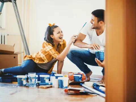 A couple, surrounded by paint cans.
