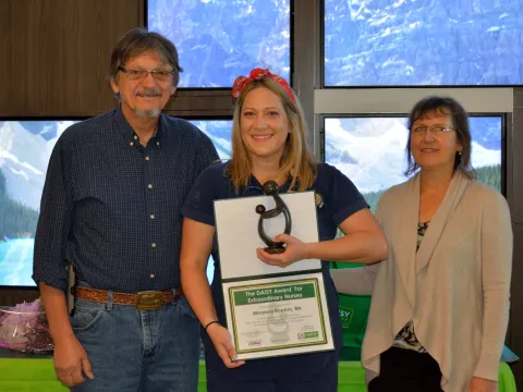 Miranda Boehm, a registered nurse at AdventHealth Fish Memorial, received the DAISY award, an international program that rewards and celebrates extraordinary clinical skill and compassionate care provided by nurses. Pictured here: Boehm (center) stands with her parents Robert and Christine Young.