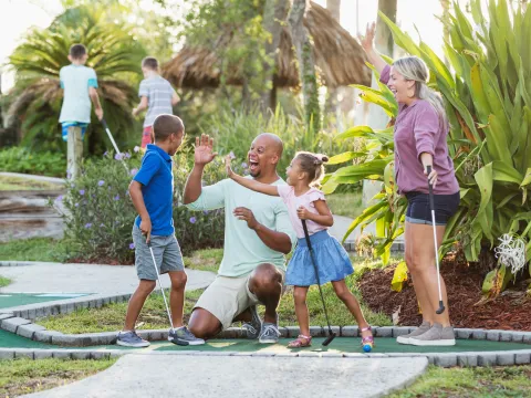 A Family Congratulates Their Son For Winning at Putt Putt Golf.