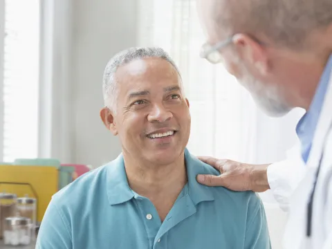A Caucasian doctor consoles his male patient.
