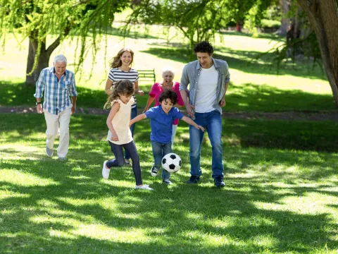Family runs together after a soccer ball