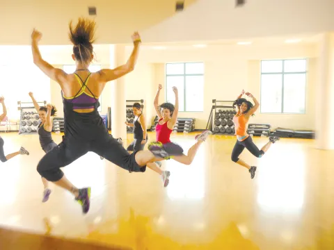 A group of women exercising at the gym while doing a group class.