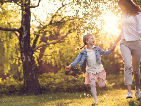 Mother and daughter skipping.