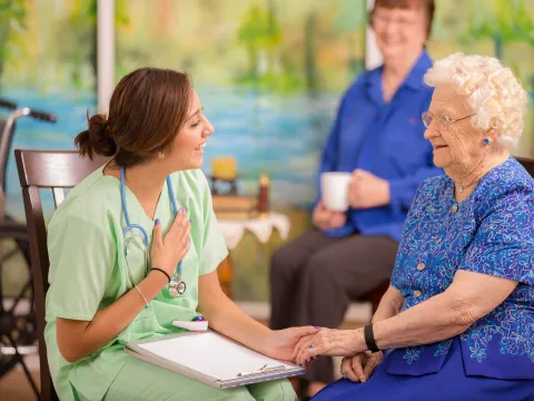Nurse talking to mother and daughter.