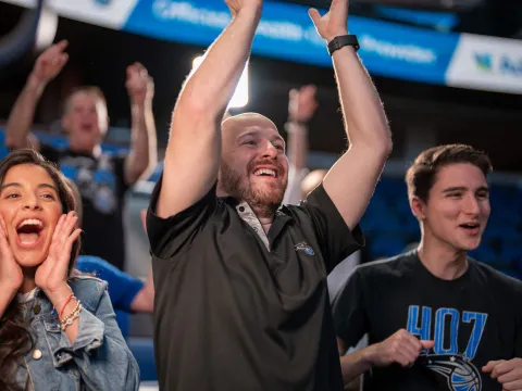 Fans cheering at an Orlando Magic game.
