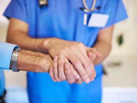 Nurse holding patient's hand