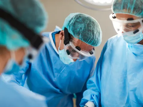 Dr. Tran with a surgical team in the operating room.