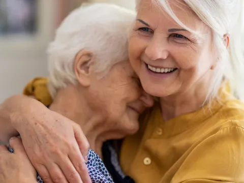 Senior Woman Embracing Older Woman