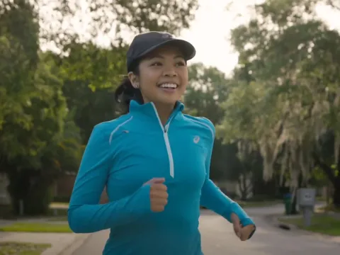 A woman in athletic clothing running outdoors