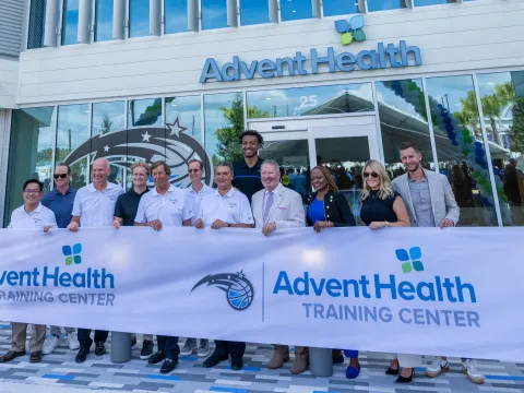 AdventHealth and Orlando Magic executives pose with Orlando Magic player, Wendell Carter Jr. in front of the new AdventHealth Training Center 