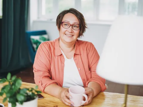 A smiling woman sitting at a desk.