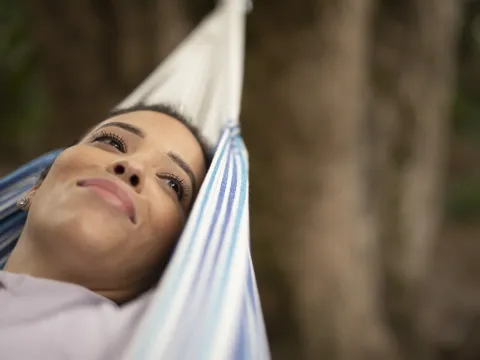 Woman relaxing in hammock outdoors
