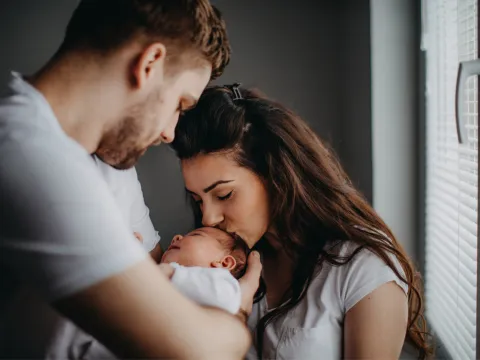 A young couple holding their newborn baby