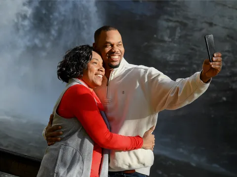 Couple taking a selfie in front of a waterfall.